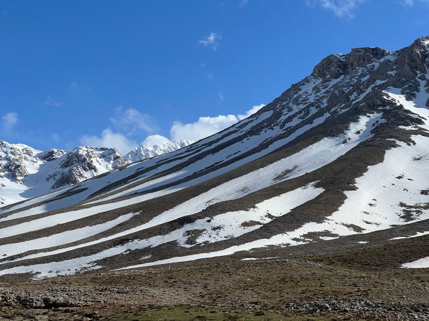 Breathtaking view of snow-covered mountain peaks against a bright blue sky.